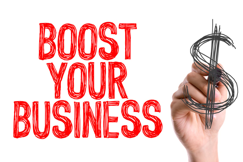 Dłoń z markerem pisząca Boost Your Business