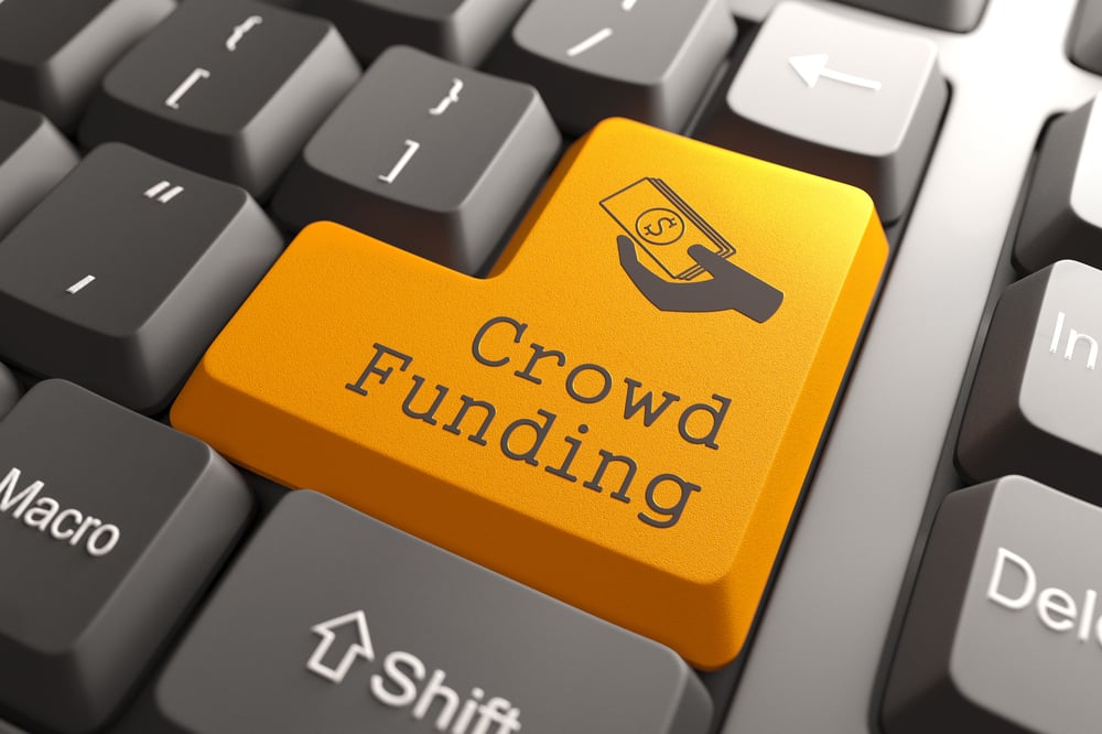 Pomarańczowy przycisk crowdfundingu na klawiaturze komputera. Koncepcja internetowa.
